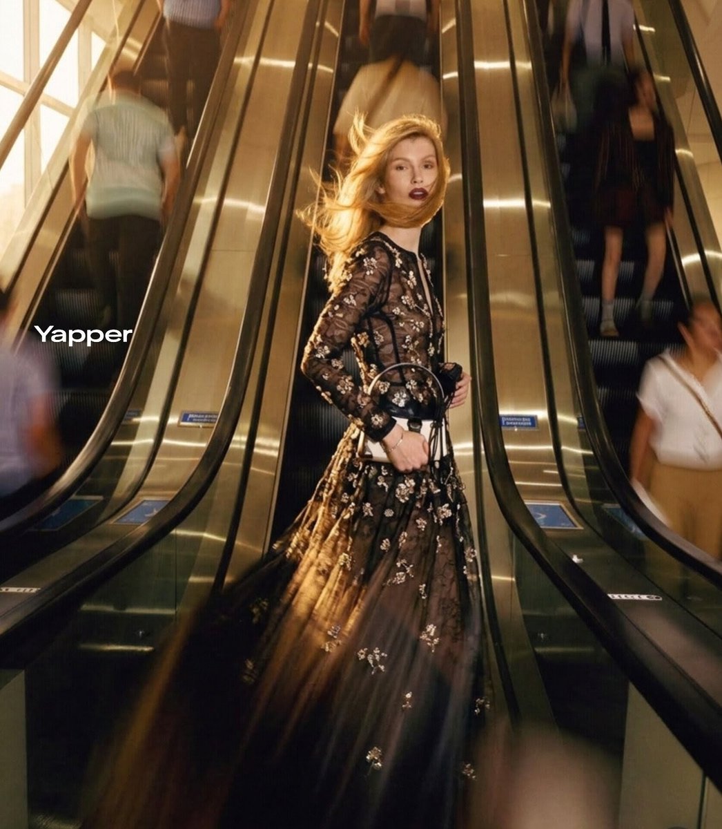 Ultra-realistic cinematic fashion photograph of a stylish blonde woman standing confidently between…
